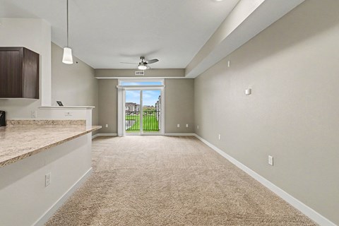A spacious living room with a 9 foot ceiling, carpeted floor and a ceiling fan at The Reserve at The Reserve at Destination Pointe in Grimes, IA 50111