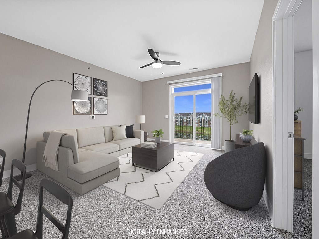 A modern living room with a 9' ceiling, grey sofa, a black armchair at The Reserve at Destination Pointe apartments, Grimes, IA