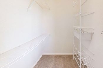 A walk-in closet with wardrobe organizers at The Reserve at Destination Pointe apartments, Grimes, IA