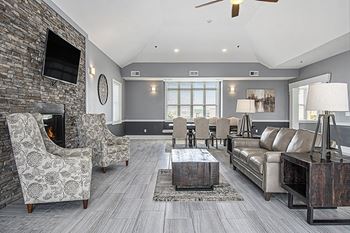 A community building with a fireplace and a television on the wall at The Reserve at Destination Pointe apartments, Grimes, IA 50111