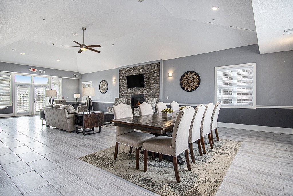 A modern clubhouse dining room with a wooden table and chairs at The Reserve at The Reserve at Destination Pointe in Grimes, IA 50111