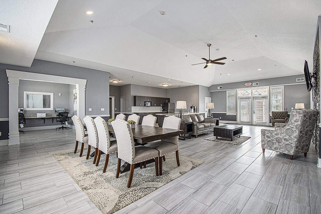 A modern community room with a large table and chairs at The Reserve at The Reserve at Destination Pointe in Grimes, IA 50111