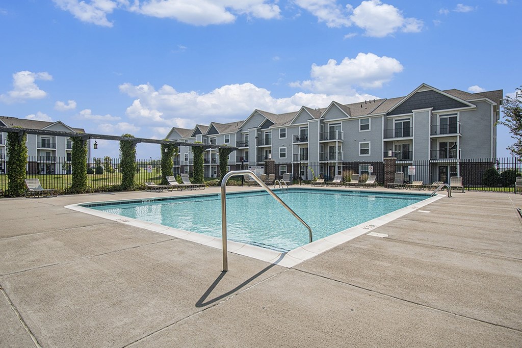 A swimming pool in front of apartment buildings at The Reserve at The Reserve at Destination Pointe in Grimes, IA 50111