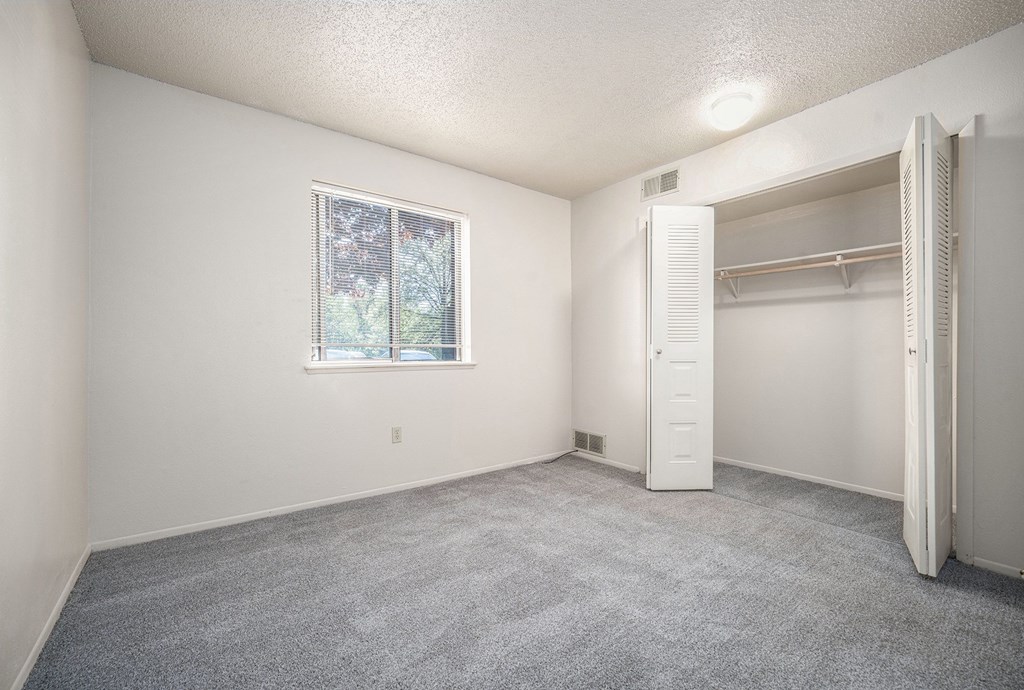A bedroom with a window and a closet at Seville Apartments, Michigan