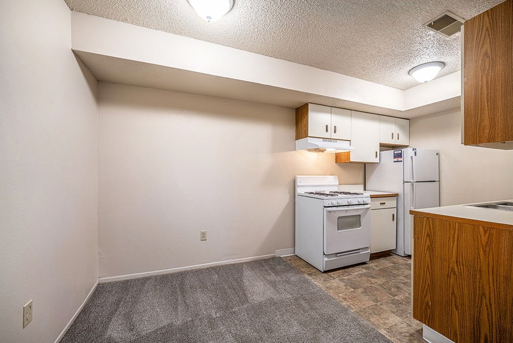 A kitchen with white appliances and a dining room at Seville Apartments, Michigan