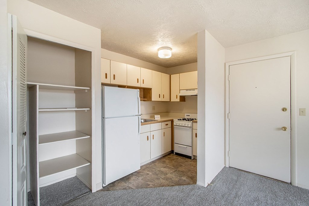 A kitchen with white appliances and cabinets