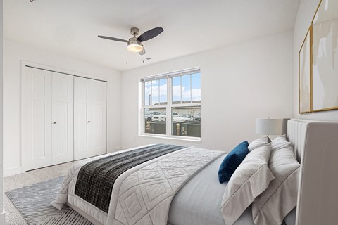 A bedroom with a large bed and a ceiling fan.