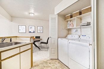 A kitchen with a washer and dryer at South Bridge Apartments in Fort Wayne, IN