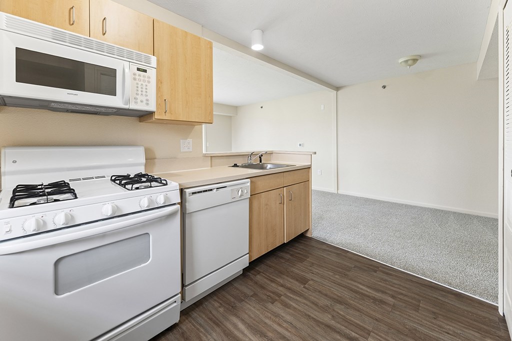 A kitchen with a white stove and microwave above it at Stoney Pointe Apartment Homes, Kansas