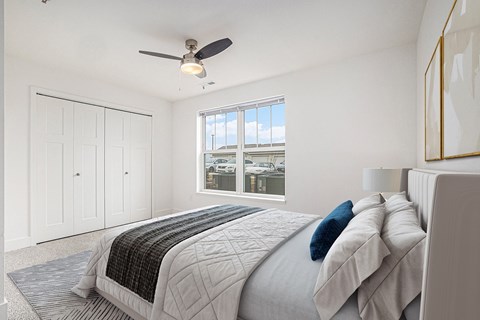 a white bedroom with a large bed and a ceiling fan at Stoney Pointe Apartment Homes, Wichita, KS