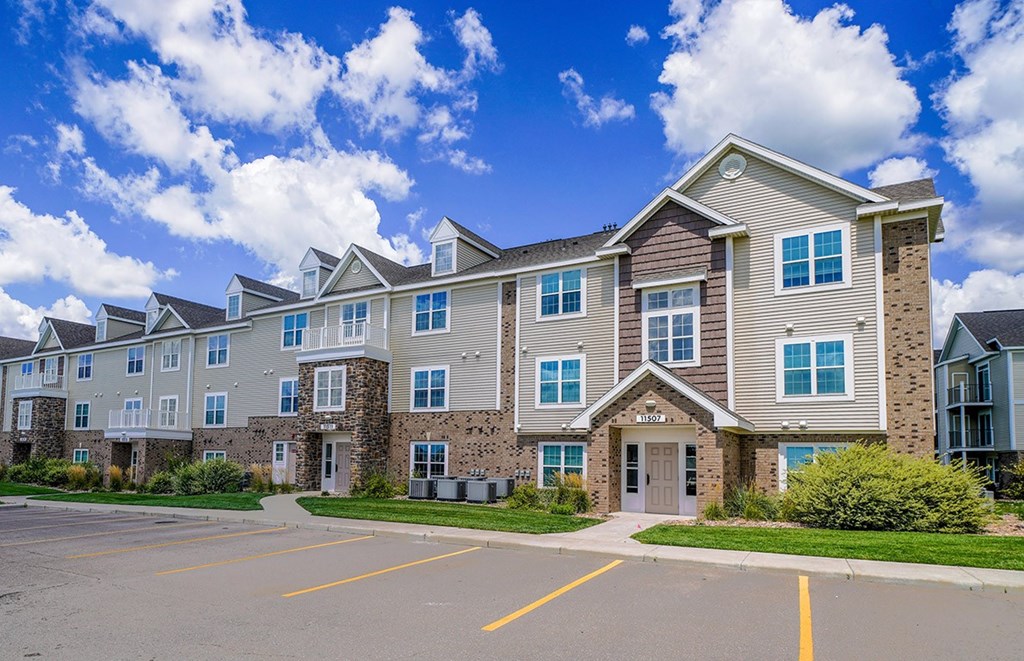 A large apartment building with a parking lot in front at Stoney Pointe Apartment Homes, Kansas, 67226