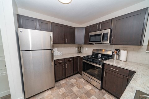 a kitchen with stainless steel appliances and brown cabinets