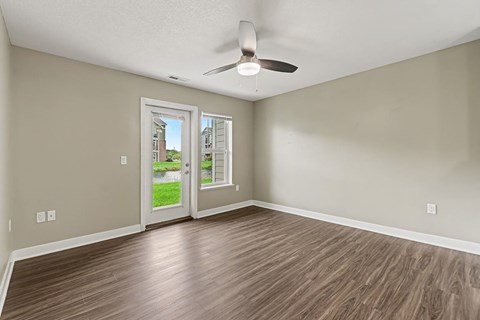 A room with a ceiling fan and wooden flooring.
