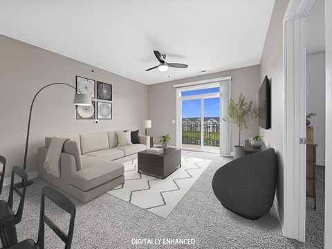 A modern living room with a grey sofa, a black armchair, and a television on the wall.