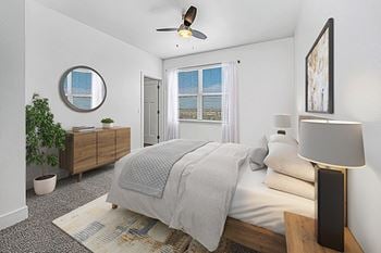 A bedroom with a bed, a ceiling fan, and a closet at Strathmore Apartment Homes in West Des Moines, IA