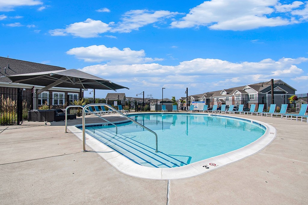 A large outdoor swimming pool with lounge chairs at Strathmore Apartment Homes, West Des Moines, IA