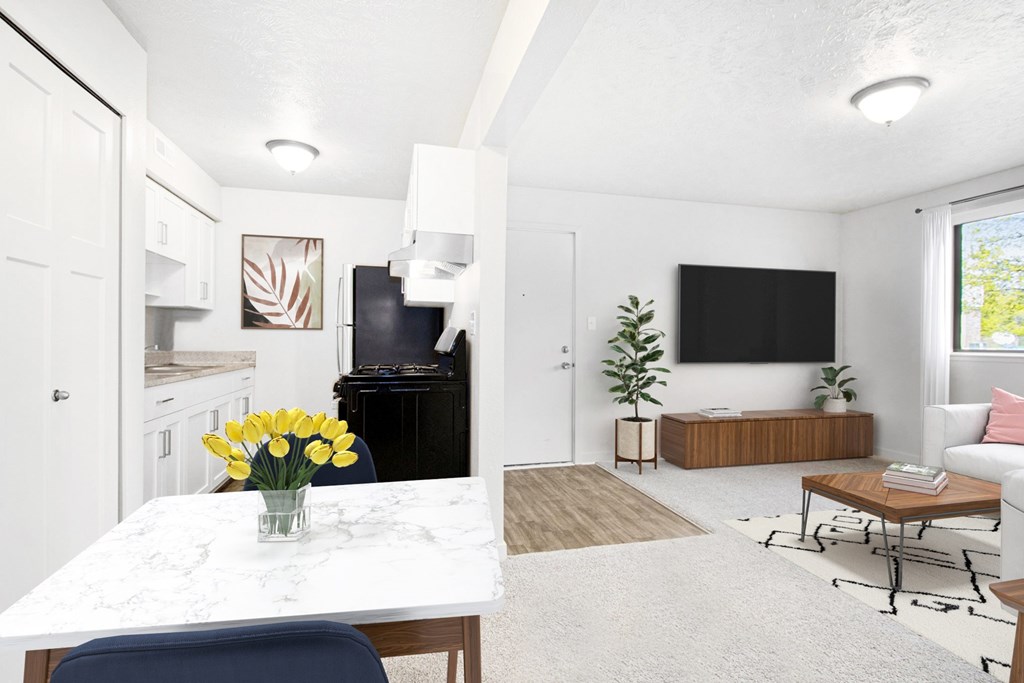 A dining and living room with a white table and chair at Swiss Valley Apartments in Wyoming, MI
