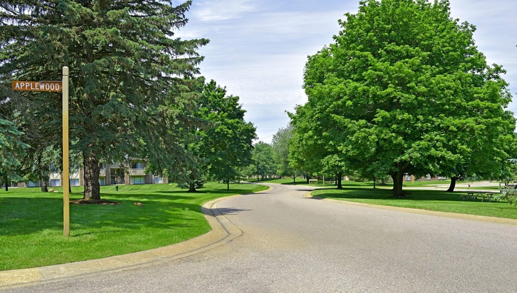a street with trees on both sides and a street sign in the middle of the road  at Sycamore Creek Apartments, Michigan