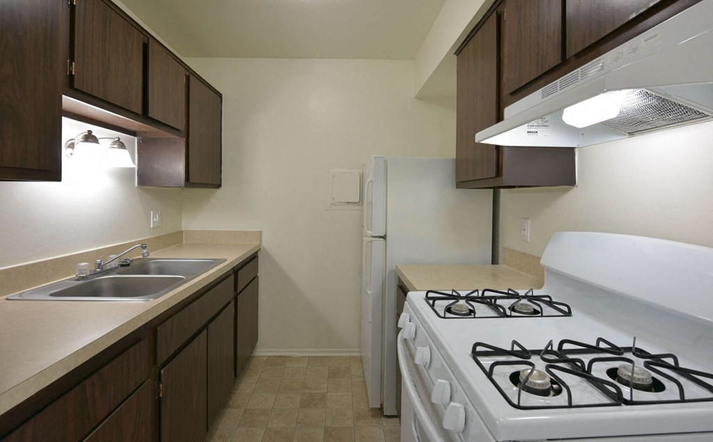 a kitchen with a stove sink and refrigerator  at Sycamore Creek Apartments, Michigan
