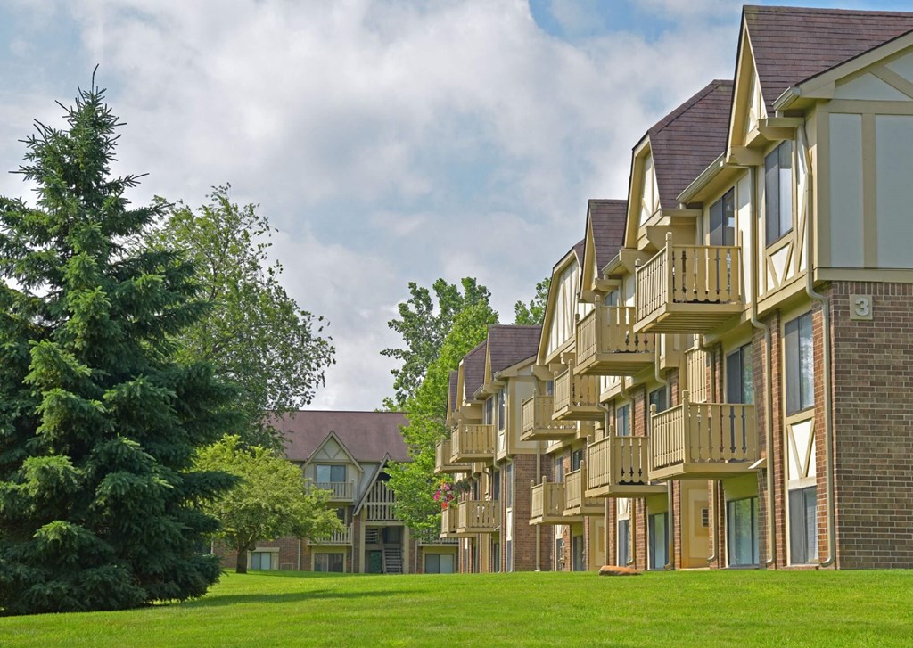 a large green lawn in front of an apartment complex at Sycamore Creek Apartments, Lake Orion