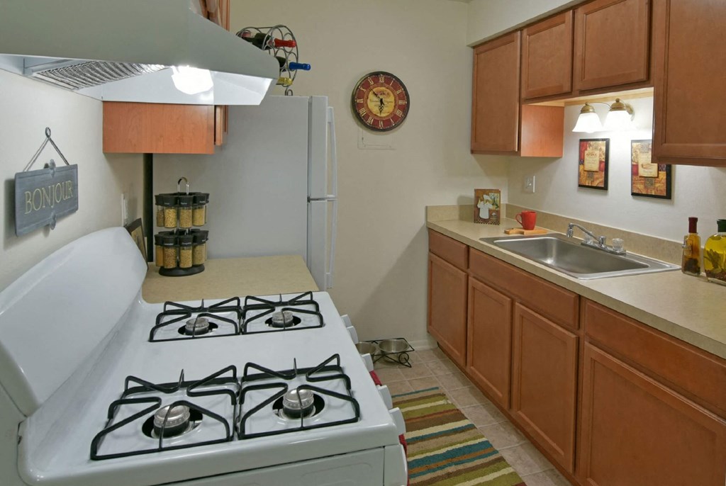a kitchen with a stove top oven next to a sink at Sycamore Creek Apartments, Lake Orion, 48359