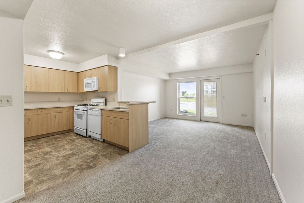 A kitchen with wooden cabinets and a white dishwasher at Tall Oaks Apartment Homes, Michigan, 49009