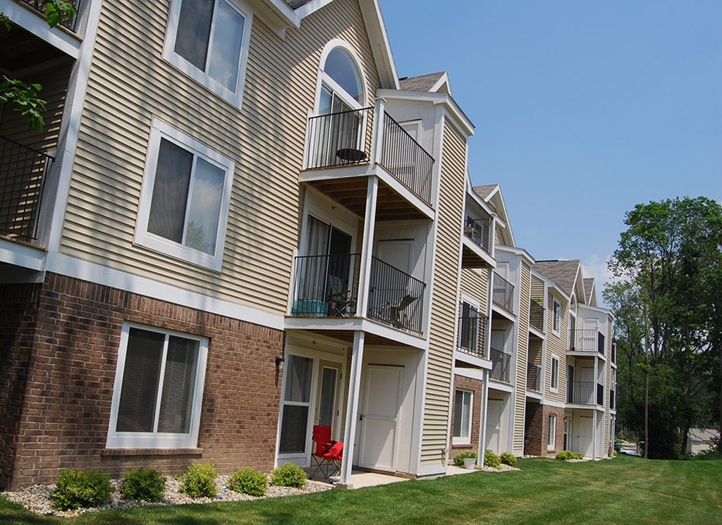 An exterior apartment building with private patios and balconies at Tall Oaks Apartment Homes, Kalamazoo, MI, 49009