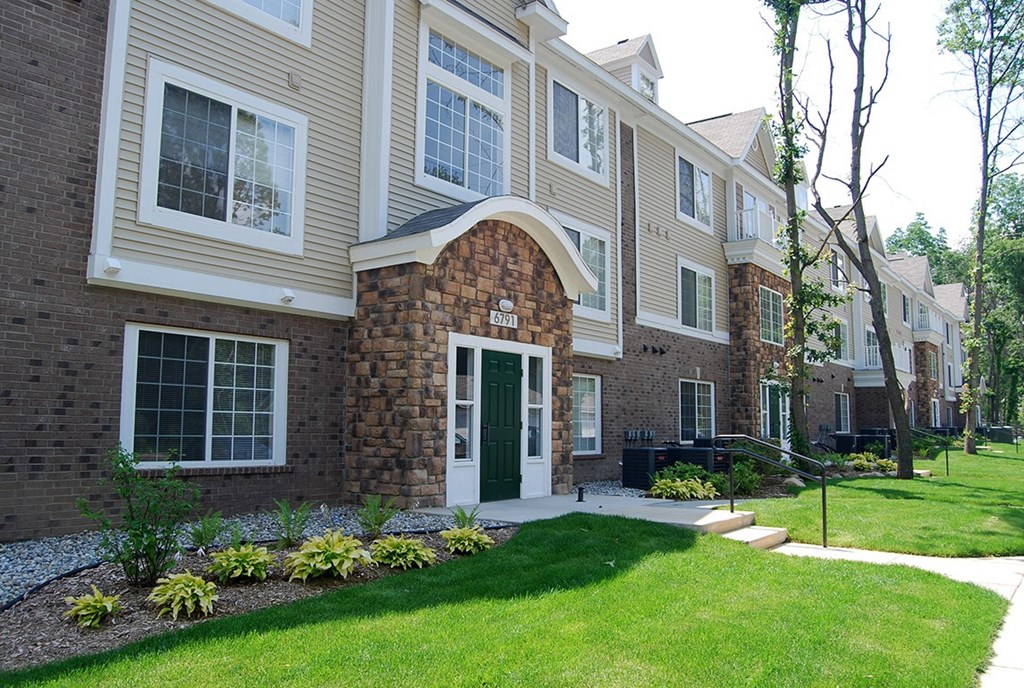 Apartment building with a green lawn in front at Tall Oaks Apartment Homes, Kalamazoo, MI, 49009