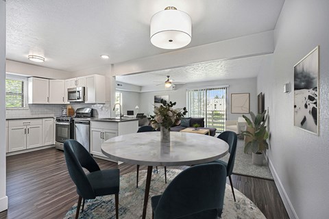 A modern kitchen with a dining table set for four.
