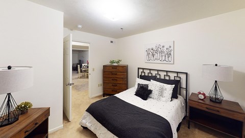 A bedroom with a bed, nightstand, and lamp at Tracy Creek Apartment Homes in Perrysburg, OH