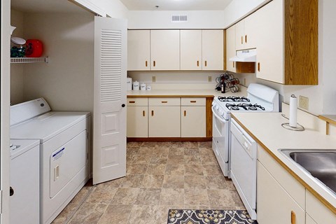 A kitchen with white appliances and wooden cabinets at Tracy Creek Apartment Homes in Perrysburg, OH