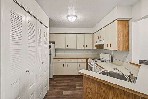 Kitchen with louvered closet doors and wood accents at Tracy Creek Homes Apartments, Perrysburg, Ohio