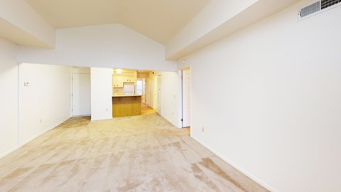A spacious living room with a cathedral ceiling and plush carpet at Tracy Creek Apartment Homes in Perrysburg, OH