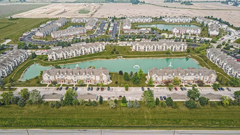 A large aerial view of an apartment complex with a pond in the middle at Tracy Creek Apartments, Perrysburg