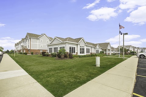 A leasing office and community building with a flag on a pole in front at Tracy Creek Apartments, Perrysburg