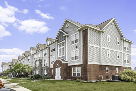 An exterior apartment building with a clear blue sky above at Tracy Creek Apartments, Perrysburg