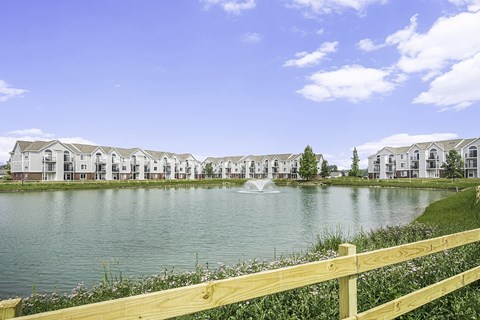 A row of apartments with a fountain in the middle of a pond at Tracy Creek Apartments, Perrysburg