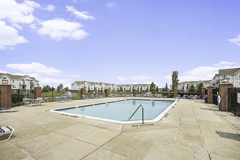A large swimming pool with Wi-Fi surrounded by a concrete patio and a fence at Tracy Creek Apartments, Perrysburg