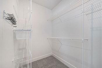 A walk-in closet with wardrobe organizers at Trade Winds Apartment Homes in Elkhorn, NE