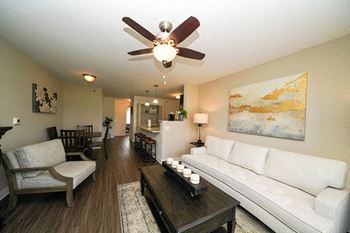 A living room with a white couch and a painting on the wall at Trade Winds Apartment Homes in Elkhorn, NE