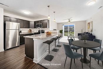 A modern kitchen with a breakfast bar and dining table and chairs at Trade Winds Apartment Homes, Elkhorn, NE