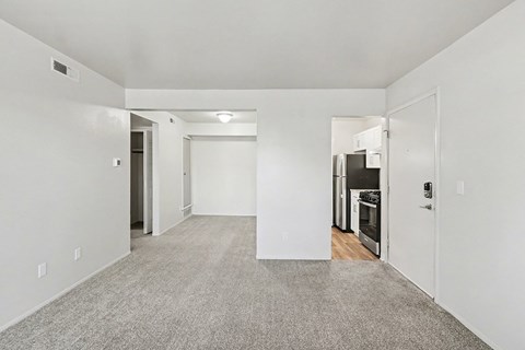 A spacious, empty dining room with a breakfast bar at Trappers Cove Apartments, Lansing