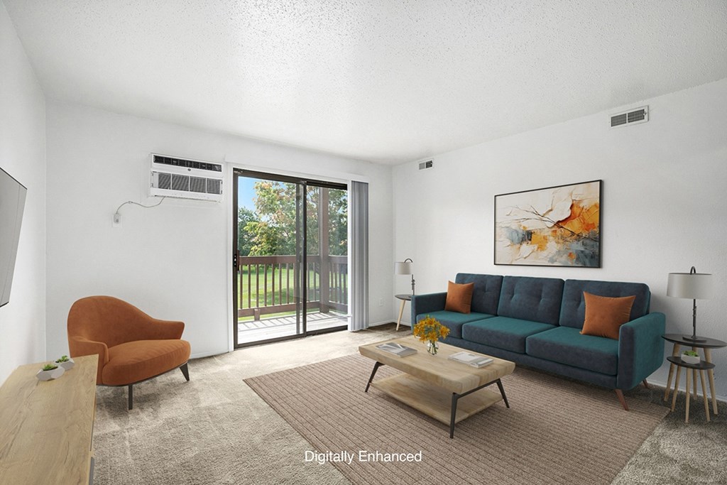 A living room with a couch, a brown chair, and a painting on the wall at Trappers Cove Apartments, Michigan, 48910