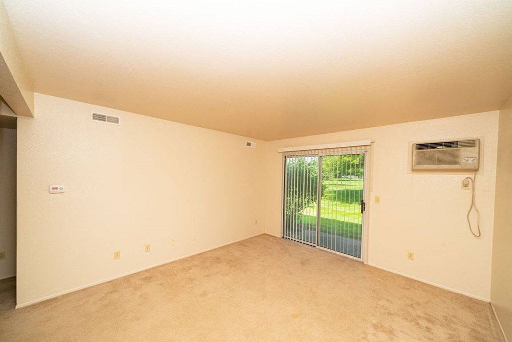 Living Room Leads to Private Patio at Trappers Cove Apartments, Lansing, MI, 48910
