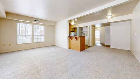A spacious room with a carpeted floor and a wooden cabinet.