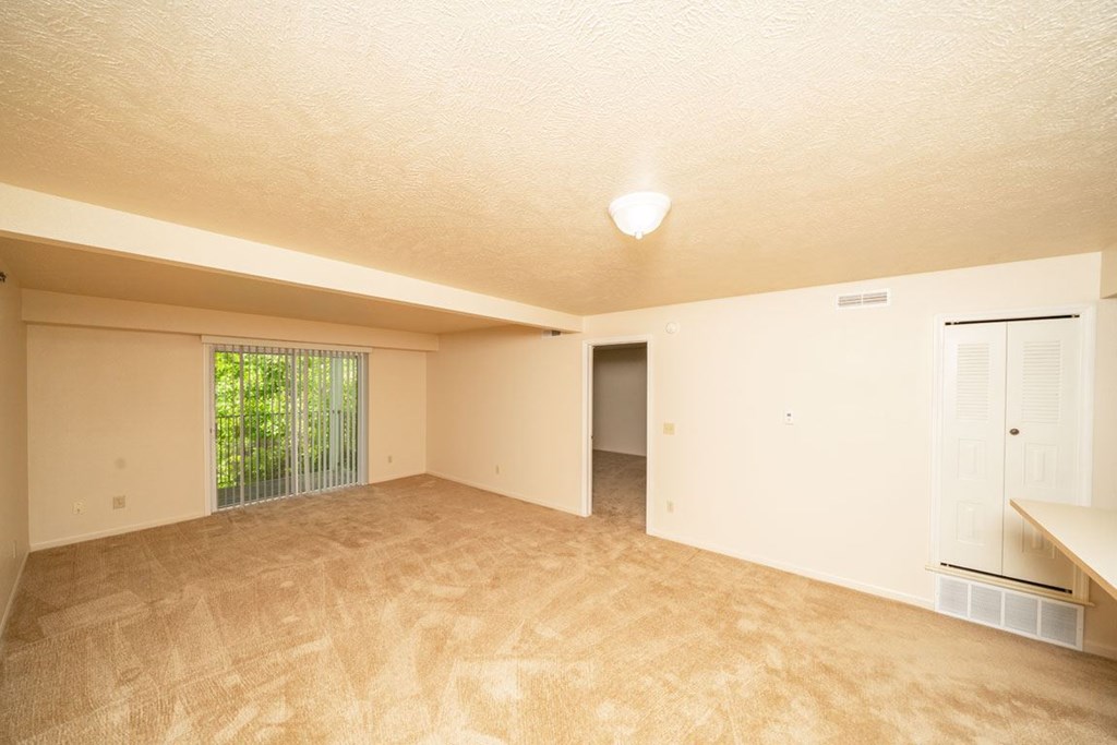 Open Living Room Leads to Balcony at Trillium Pointe Apartment Homes in Jackson, MI