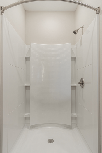 a walk in shower with white tile and a white shower curtain at 24 at Bloomfield, Bloomfield Township, Michigan