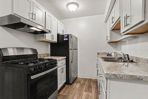 A kitchen with a black stove top oven and a black refrigerator.