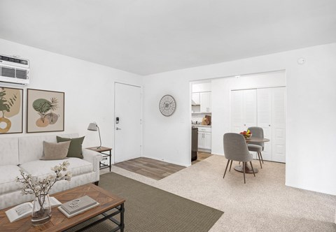 A living room with a white couch, a coffee table, and a rug.