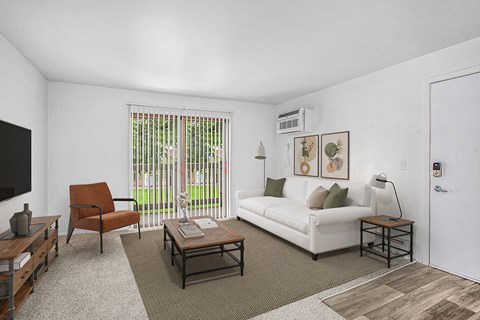 A living room with a white couch, a brown chair, and a coffee table.